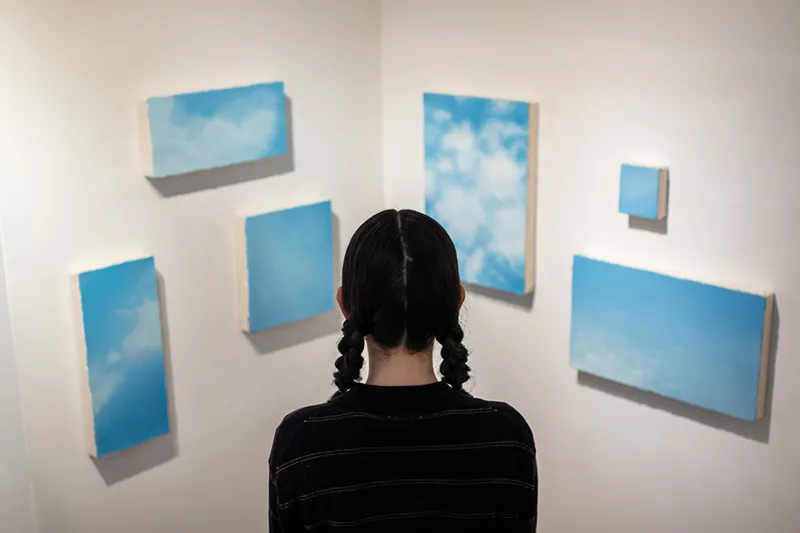 個展会場にて出展作品《星を見ること》シリーズを観る水橋